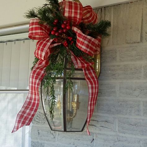 Christmas Carriage Light Decor, Bows On Outdoor Lights, Garage Door Lights Christmas Decorations, Garage Light Christmas Swag, Cellophane Wrapping Ideas Christmas, Christmas Bows On Outdoor Lights, Outdoor Light Fixture Christmas Decor, Garage Lights Christmas Decor, Outdoor Bows Christmas