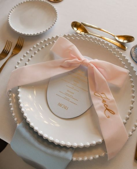 Pretty as a picture wedding table setting // ⁠ ⁠ This elegant wedding table setting perfectly pairs contemporary wedding stationery from London based Letterpress wedding stationer @inkandpaper_ldn with a luxurious name embroidered velvet bow from @theembroiderednapkincompany.⁠ ⁠ ⁠ The chic, oval shaped menu card (in the most delicate shade of pale blue with hot gold foil detailing) and bow embellishment sit atop pearl edged white presentation plates, beautifully elevating the elegance of the ... Romantic Wedding Table Settings, Modern Wedding Aesthetic, Bow Bouquet, Elegant Wedding Table, Elegant Spring Wedding, Flowers London, Historic Art, Desserts Menu, Letterpress Wedding