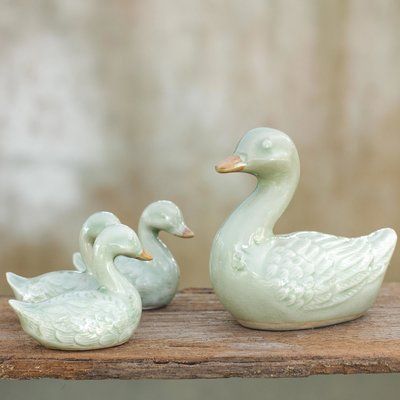 These whimsical figurines depict a mother duck and three charming ducklings. The Thai artisan works in this cool green ceramic to create the charming family. | Rosalind Wheeler Remer Ceramic 4 Piece Figurine Set Ceramic in Green, Size 3.5 H x 3.7 W x 2.6 D in | Wayfair | Home Decor Celadon Ceramics, Pottery Animals, Cool Green, Flower Sculptures, Portrait Pictures, Clay Animals, Ceramic Animals, Decor Figurines, Ball Lights