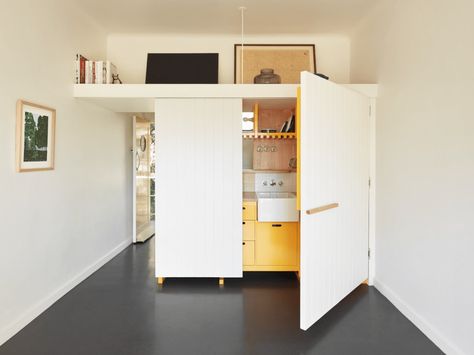 Micro-Apartments in Australia | Never Too Small Raised Platform Bed, Never Too Small, Black Tile Bathrooms, Block Out Curtains, Bed Nook, Matte Black Kitchen, Micro Apartment, Ceiling Storage, Black Countertops