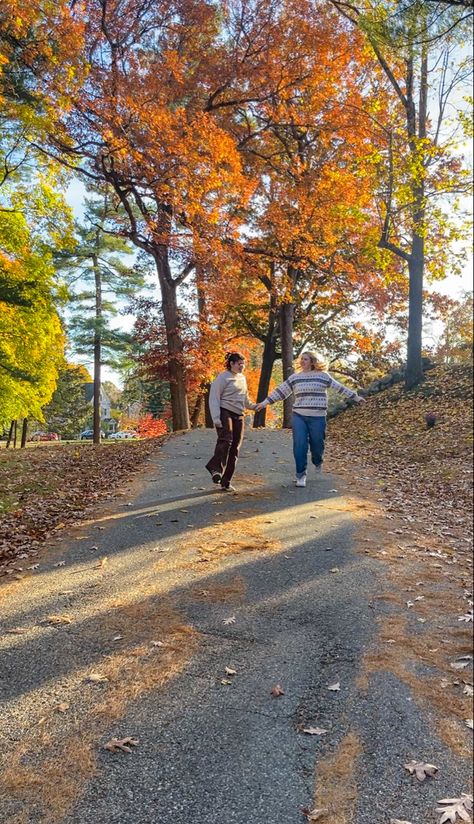 Two girls running down a street with fall trees in the background Fall Couple Aesthetic Wlw, Wlw Fall Dates, Fall Wlw Aesthetic, Fall Lesbian Couple Aesthetic, Wlw Fall Aesthetic, Wlw Autumn, Fall Date Aesthetic, Wlw Date Aesthetic, Wlw Halloween