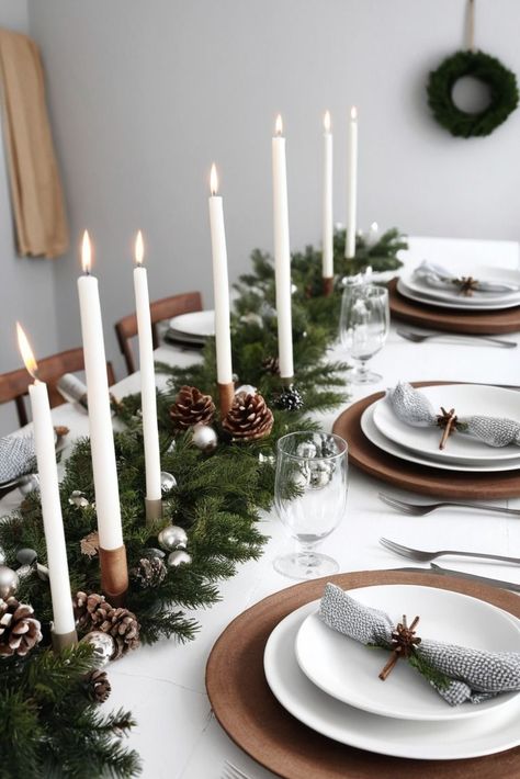 Opt for simple wreaths, wooden stars, and minimalistic garlands. White fairy lights and candles create a peaceful ambiance. Christmas Lunch Table Setting Simple, Winter Place Settings, Simple Christmas Tablescapes Ideas, Minimal Christmas Table Decor, Nordic Christmas Table, Modern Christmas Tablescape, Winter Table Settings, Christmas Dinner Table Ideas, Scandinavian Christmas Table