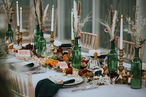 Trade clear bottles for bold green or deep burgundy colors to add a contrasting pop of color to the table. This photo is proof that adding some neutral florals or pampas grass to the bottles is a great way to add texture as well for a romantic estate wedding. Also, check out this creative runner made of real fruit! Click through for more wine bottle centerpieces! #romanticwedding #estatewedding #winebottlecenterpieces #weddingcenterpieces #weddingtablescapeideas Graze Table, Wine Bottle Wedding Centerpieces, Vintage Parasol, Table Elements, Wine Bottle Centerpieces, Wedding Wine Bottles, Colored Glass Bottles, Long Candles, Bottle Centerpieces