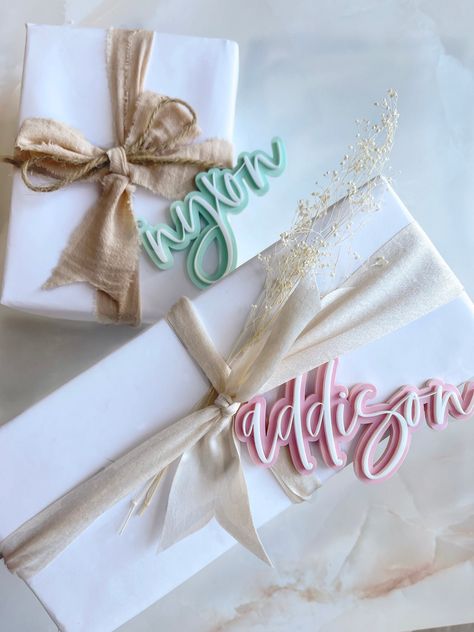 "Our acrylic personalized name gift tags add an adorable touch to your gift baskets! Personalized using beautiful modern calligraphy, these 3D laser cut tags add a pop of fun to your wedding, birthday, and holiday gifts. Mix and match and choose from a variety of colors! Sold individually Measurements: Approximately 4\" - 4.5\" wide (height / width will vary based on the length of the name) Material: Acrylic White twine included **Quick shipping -- All orders ship within 2 BUSINESS DAYS" Gift Tags Personalized, Acrylic Christmas Gift Tags, Personalised Gift Tags, Acrylic Gift Tag Ornaments, Acrylic Stocking Name Tags, Cute Gift Wrapping Ideas, Valentines Day Baskets, Christmas Gift Tags Personalized, Easter Tags