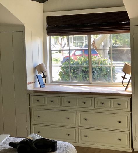 How I repurposed an old dresser and turned it into a beautiful built-in for my daughter's bedroom and completely transformed the space. Built in closets, interior dormer window, swiss coffee white paint, laminate wood floors, 1950 beach cottage Diy Dresser Built In, Built In Closet Around Window, Dresser In Front Of Window, Built In Dresser In Bedroom, Swiss Coffee White, 1950 Beach, Diy Dresser Build, Built In Closets, Bunk Room Ideas