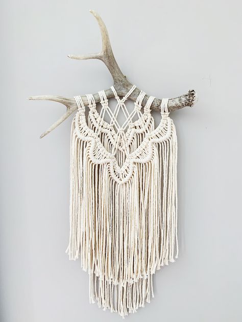 The FLORENCE: This unique handmade macrame wall hanging features an intricate design of natural cotton cording and hangs from a beautiful deer antler.  The Florence is a great decor addition for almost any room, especially nurseries, bathrooms and entryways, but can be hung anywhere. This piece makes a great gift, especially for outdoor enthusiasts. Each is truly one-of-a-kind. - Other colours available (based on availability) - Made to order - Antlers are natural products and may vary - Antler tips can be gold leaf painted for additional cost Antler Macrame, Macrame Mural, Driftwood Macrame, Antlers Decor, Antler Crafts, Antler Wall, Makramee Diy, Antler Art, String Crafts