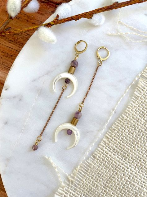 These are extra long, unique, bohemian style earrings featuring white shell double horn (crescent) focal beads, chevron amethyst, brass beads, and brass chain.  This style hangs approximately 3.75" inches from the lobe on the longer side. They feature 22k gold plated leverback closures.  These earrings are very lightweight and should be suitable for everyday wear.  If you are not satisfied with your purchase, contact me within 14 days, and return your earrings in the original packaging for a ful Horn Earrings, Kitchen Witchery, Crescent Earrings, Handmade Jewlery, Chevron Amethyst, Crescent Moon Earrings, Brass Beads, Witchy Jewelry, Moon Light