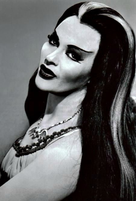 Full Name: Lily Dracula Munster Age: Varies (but more than 137 years old) Birthplace: Transylvania Appearance: Vampirelike; silver streak in hair Siblings: Brother Lester and unnamed sister Abilities: Reading palms and cooking Occupation: Full-time housewife Preferences: Wears Chanel No. 13 perfume ("the most exotic") Noticeable Qualities: Undying devotion to husband and family; sensitivity http://www.munsters.com/lily_munster.php Cultura Punk, The Munster, Lily Munster, Yvonne De Carlo, Elvira Mistress Of The Dark, Rooney Mara, Album Foto, The Munsters, Classic Monsters