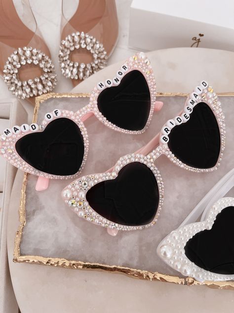 All heart eyes for these hand studded sunnies with multi sized pearls. Each pair is hand-made and therefore unique. Shipped in the cutest white box with included sunglasses sleeve. Perfect for travel and doubles as the sweetest gift. Ready to ship! Limited quantities. Final Sale Bridesmaid Heart Sunglasses, Bridesmaid Proposal Cowgirl, Bachelorette Sunglasses Diy, Bridesmaid Accessories Ideas, Sunglasses Bridesmaids, Bachelorette Gifts For Bridesmaids, Bachelorette Gifts For The Bride, Bridesmaid Proposal Ideas Unique, Unique Bachelorette Party Ideas