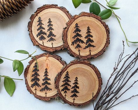 A set of four (4) woodburned coasters. Each one with a unique set of trees!  They are hand-burned on locally sourced, live edge Douglas-fir rounds. The coasters are then finished with 2 coats of a clear polycrylic for wood protection against heat and moisture from various beverages!  Coasters have beautiful natural live-edge bark, and are of course perfectly flat. This set is the perfect addition to any table, desk, or home!  **Each piece of wood is unique, and each tree is hand drawn and burned Wood Burning Ideas Coasters, Wood Burning Designs Coasters, Coaster Wood Burning, Small Wood Rounds Crafts, Wood Burning Coasters Ideas, Wood Burning Trees, Easy Wood Burning Ideas For Beginners, Wood Burn Coasters, Simple Wood Burning Patterns