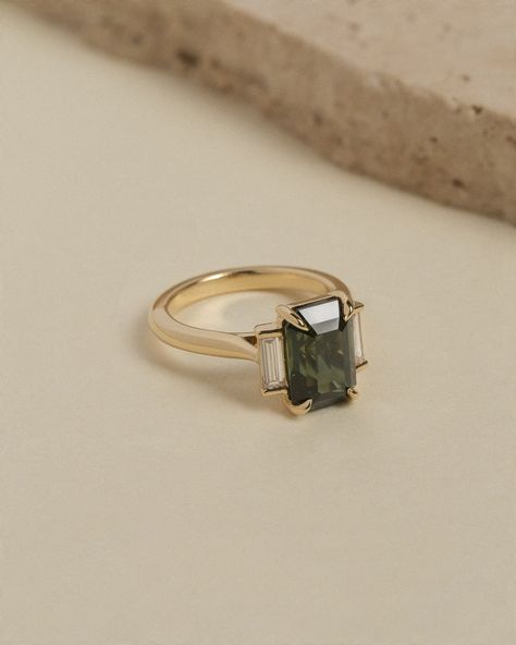 BESPOKE | One of our most recent bespoke creations. Crafted in 18k yellow gold, this trilogy style engagement ring features an emerald cut green sapphire flanked by baguette cut white diamonds set with end caps.⁠ ⁠ R9843 Green Sapphire Ring, Green Sapphire, Baguette Cut, White Diamonds, Emerald Cut, Diamond White, Sapphire Ring, Olive Green, Bespoke