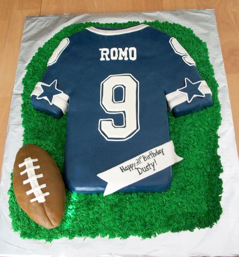 Football Jersey Cake - This is a Dallas Cowboys (Tony Romo) jersey cake for a 21st birthday.   It is a chocolate fudge cake covered in fondant with fondant and royal icing decorations, grass is buttercream and the football is made of crispy treats. Football Jersey Cake, Dallas Cowboys Birthday Cake, Dallas Cake, Dallas Cowboys Cake, Dallas Cowboys Birthday, Dallas Cowboys Party, Cowboy Birthday Cakes, Jersey Cake, Cowboy Cakes