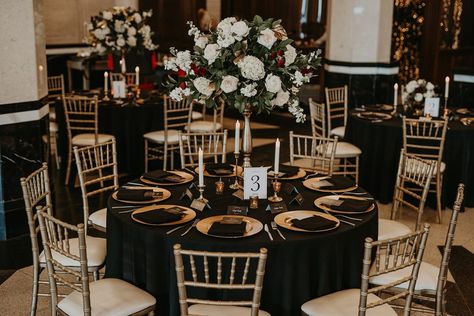 Modern Wedding Reception that takes you back to a different time - Gold Chaivari Chairs, Gold Chargers, Black Table Linens, with Tall Floral Centerpieces and Taper Candles in a Historic Venue - Wedding Table Decor - Wedding Reception Decor #dallasweddingplanner #dallaswedding #dallasweddings #weddingplanner #weddingplanning #weddingdetails #planner #texasweddingplanner #texaswedding  #txweddings #txwedding #wedding #weddingday #weddinginspiration #engagement #proposal  #realwedding Black And Gold Wedding Reception Tables, Black And Gold Sequin Tablecloth, Black Linen Gold Charger, Black And Gold Venue Decorations, Wedding Table Decorations Black And Gold, Black Table Cloth Boho Wedding, Black Gold And Ivory Wedding Table Settings, Black Linen Wedding Table Centerpieces, Black Tablecloth Decor Wedding