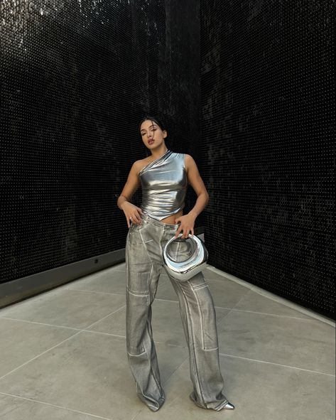 Silver metallic top with grey pants and chromed bag Fashion Nova Silver Metallic Outfits, Metallic Top Outfit Silver, All Silver Outfit, Metallic Outfit Ideas Party, Silver Bag Outfit Metallic, Silver Outfit Party, Silver Concert Outfit, Metalic Outfits Ideas, Metallic Bag Outfit