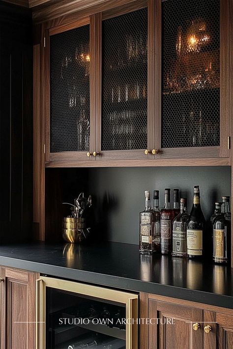 A sophisticated home bar with rich dark oak cabinets, brass mesh doors, and a moody black countertop, perfect for entertaining.  #InteriorDesign #OwnArchitecture #Bar #HomeBar #LuxuryHome Dark And Moody Bar, Dark Home Bar, Black Wet Bar, Moody Bar, Dark Oak Cabinets, Brass Mesh, Black Countertop, Home Bar Rooms, Home Redesign