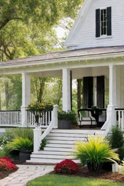 White house with a cozy front porch, potted plants, and blooming flowers in the garden. 1950s Farmhouse Exterior, White And Black Porch, Landscape Design Farmhouse, Modern Farmhouse Front Yard, Traditional Farmhouse Exterior, French Country Cottage Exterior, Colonial Farmhouse Exterior, Beautiful Farmhouse Exterior, Classic White Farmhouse