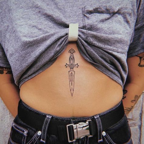 Tiny stomach dagger by Belladona Hurricane Knife Tattoo Sternum, Sternum Knife Tattoo, Women Sternum Tattoo Ideas, Dagger Sternum Tattoo Women, Tattoo Middle Of Chest Women, Athame Tattoo, Dagger Chest Tattoo Female, Dagger Sternum Tattoo, In Between Chest Tattoo