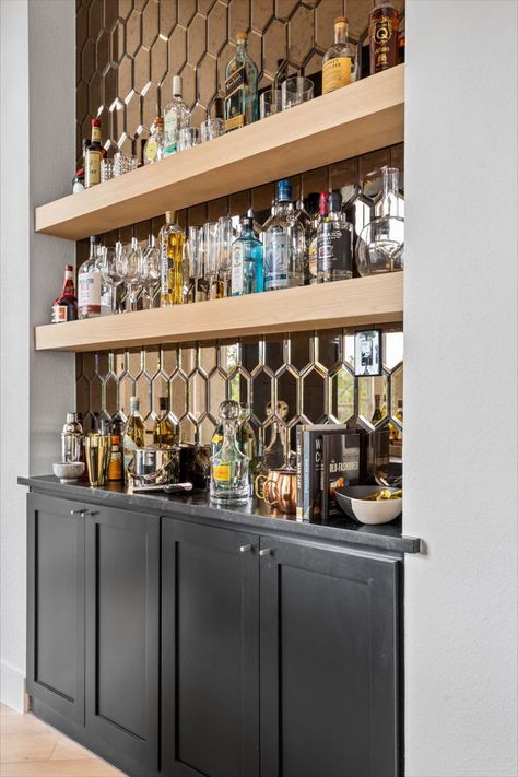 Custom wet bar design. Liquor cabinet. Black millwork design. Industrial pendant lights. Wood floating shelves. Liquor display shelving. Mirror backsplash. Black countertop. Bar Shelves Ideas Liquor, Wet Bar With Floating Shelves, Bar Shelves Ideas, Bar With Floating Shelves, Wet Bar Backsplash, Wet Bar Design, Dry Bar Ideas, Millwork Design, Liquor Display