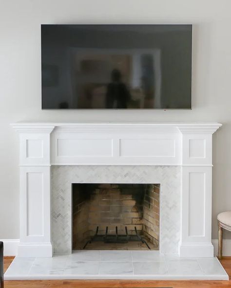 A fireplace surround makeover transformation done as a DIY with new trim moldings, herringbone marble tile and marble hearth. Fireplace Makeover With Tile, Marble Surround Fireplace, Fireplace Refacing, Fireplace Upgrade, Farm Renovation, Marble Hearth, Fireplace Backsplash, Fireplace Brick, Fireplace Trim