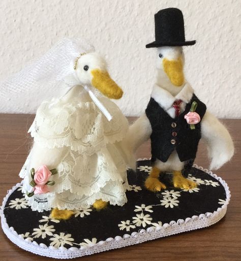 Two felted runner ducks getting married. These two are very happy and nervous on their wedding day. They have been needle felted using natural sheep's wool on a wire armature. They are dressed in clothes made from felt and lace. The buttonhole and bouquet are made with ribbons. The base is fabric covered card with braiding around. The eyes are acrylic. This item is not suitable for children under 3 due to small parts and loose fibres. The item measures L18 x W11 x H16 cm. Duck Wedding, Duck Farming, Runner Ducks, Wire Armature, Felt Art, Sheep Wool, Needle Felted, Fabric Covered, Ducks