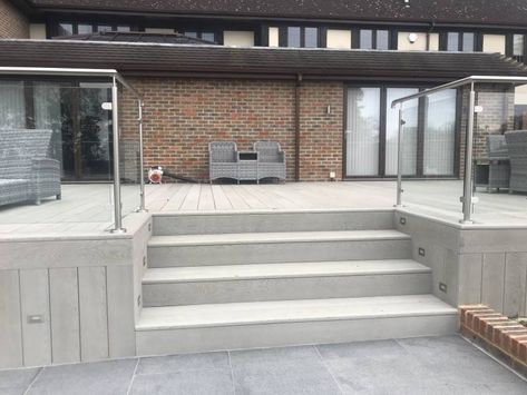 Composite Millboard Decking with glass balustrade, Brick Wall and Swimming Pool with Porcelain Patio Surround - Artificial Grass Lawns and Turf by Carrick Patio Balustrade Ideas, Decking Glass Balustrade, Millboard Decking, Porcelain Patio, Patio Railing, Glass Balcony, Raised Patio, Patio Steps, Garden Paving