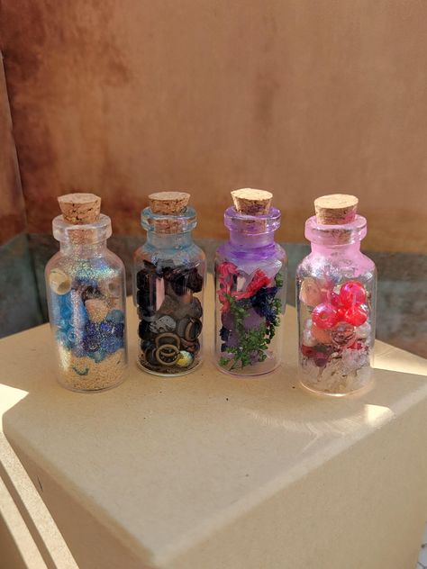 These sets of 4 small spell jars are filled with a variety of ingredients sure to be necessary for your summon needs. Each miniature bottle contains a unique combination of rock, sand, shells, flowers, herbs, and glass beads, making them practical and visually appealing. They may be small but they will perk up the surroundings. Patron Bottles, Jar Keychain, Patron Bottle, Tiny Glass Jars, Crafts With Glass Jars, Spell Jars, Beads Making, Mini Glass Bottles, Miniature Bottles