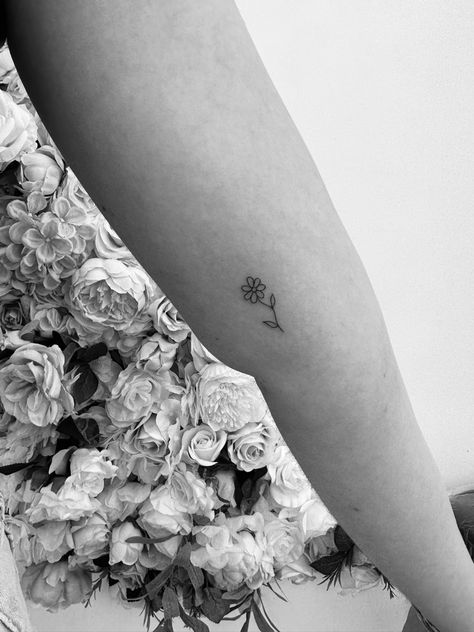 A black and white image of an arm with a small tattoo of a daisy with a curvy stem and two leaves. The tattoo is on the inside of the arm just above the elbow. Spine Scar Tattoo, Scoliose Tattoo Ideas, Surgery Tattoo Ideas, Tattoos 2023, Tattoo 2024, Scar Tattoo, Patchwork Sleeve, Daisy Tattoo, Spine Tattoo