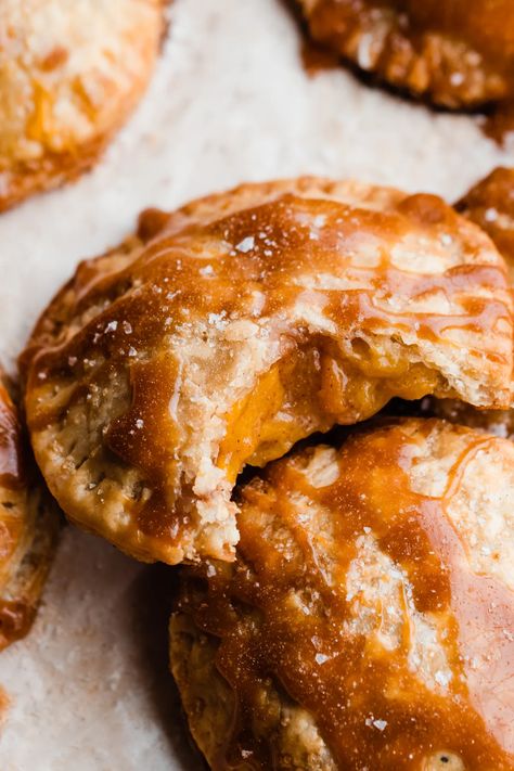 Salted Caramel Peach Hand Pies are the perfect summer dessert! Buttery, flaky crust is filled with sweet cinnamon-spiced peach pie filling, and topped with salted caramel sauce for an irresistible dessert everyone is sure to love. #peachpie #peaches #peachrecipes #handpies #peachhandpies #saltedcaramel #saltedcaramelsauce #caramelsauce #fourthofjulydessert #minidessert #minipie #dessertrecipes #summerdesserts #bluebowlrecipes | bluebowlrecipes.com Pie Crust Chips, Stephanie Simmons, Peach Hand Pies, Peach Filling, Easy Treats To Make, Peach Pie Filling, Perfect Pie Crust, Flaky Pie Crust, Salted Caramel Sauce