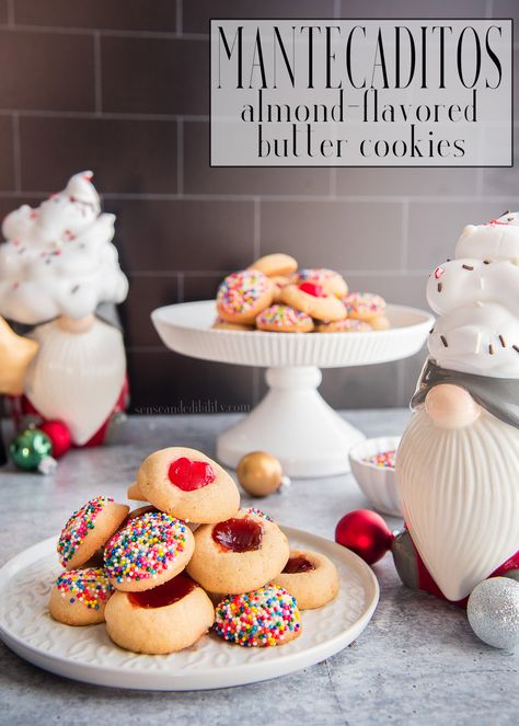 Mantecaditos are a beloved childhood cookie. This almond-flavored butter cookie is easy to make ahead and even easier to eat. Freezer-friendly, and customizable with your choice of toppings, it will be your go-to cookie recipe. #mantecaditos #galletas #biscuits #cookies #sprinkles #guavapaste #postres #galletitas #buttercookies #thumbprintcookies #holidaycookies #holidaybaking #holidayrecipes #freezerfriendly #makeahead #baking #ediblegifts #recetas #recetadegalleta #Navidades #Christmasrecipe Almond Thumbprint Cookies, Cookies Sprinkles, Latin Dishes, Almond Butter Cookies, Biscuits Cookies, Rican Food, Flavored Butter, Traditional Recipes, Black Food