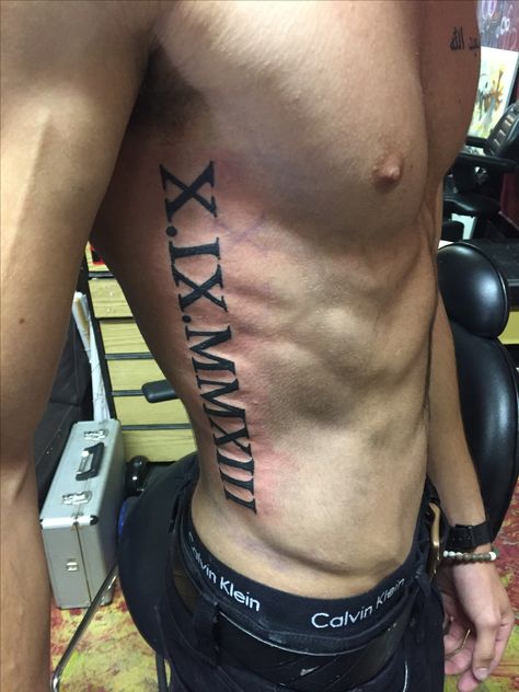 Roman Numeral Tattoo Ribs Roman Numeral Date Tattoo, Tattoo Ribs, Rib Tattoos For Guys, Roman Tattoo, Roman Numeral Tattoo, Italian Tattoos, Numeral Tattoo, Cage Tattoos, Roman Numeral Tattoos