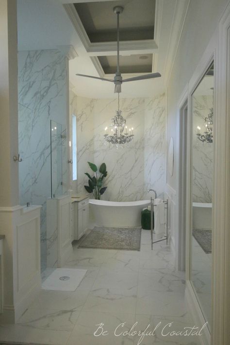 A show stopper master bath with floor to ceiling marble, an elegant soaker tub and aged silver chandelier. @ Be Colorful Coastal blog Chandelier Over Soaking Tub, Master Bath Chandelier Over Tub, Light Above Bathtub, Bathroom And Closet Ideas, Master Bath Chandelier, Repurposed Chandelier, Hollywood Regency Bathroom, Bathtub Light, Downsizing House