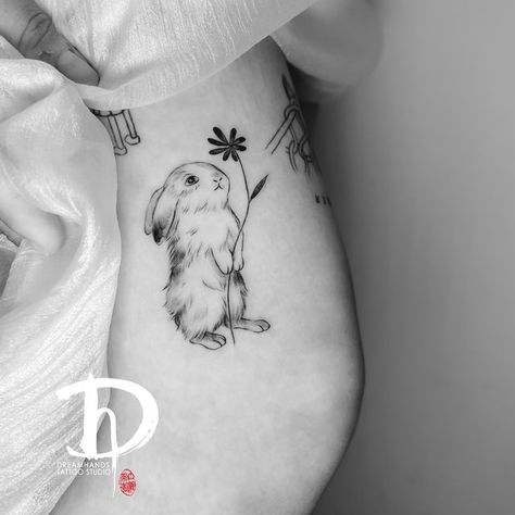 Dreamhands tattoo on Instagram: "Nancy did two cute bunnies. Keen to do more lovely pet tattoos. Online booking at www.dhtattoo.co.nz #finelinetattoo #finelinetattoo #pettattoos #smalltattoos #matchingtattoo #tattoolovers #aucklandtattoo" Bunny Holding Flower Tattoo, Bunny With Flowers Tattoo, Bunny Flower Tattoo, Baby Bunny Tattoo, Fine Line Bunny Tattoo, Cute Rabbit Tattoo, Peter Rabbit Tattoos, Bunny Tattoo Small, Ruby Tattoo