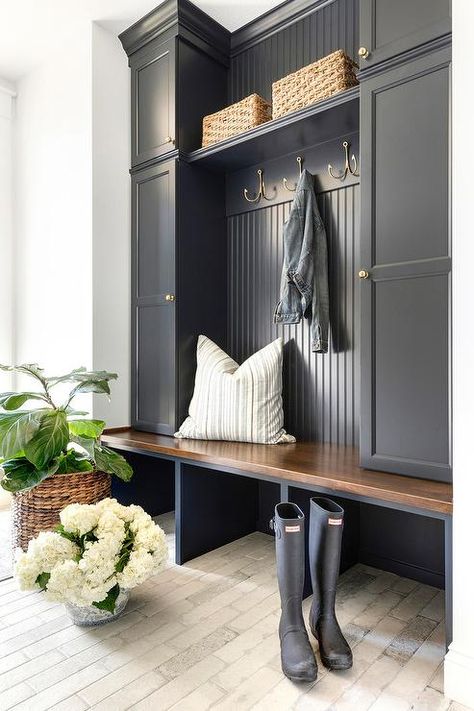 Charming black cottage style mudroom boasts light brick pavers contrasted with a black built-in bench topped with a stained wood seat fixed beneath stacked black locker cabinets adorned with antique brass knobs. Cottage Style Mudroom, Entryway Storage Ideas, Mudroom Cabinets, Mud Room Entry, Home Entryway, Mudroom Entryway, Mudroom Decor, Mudroom Laundry Room, Mud Room Storage