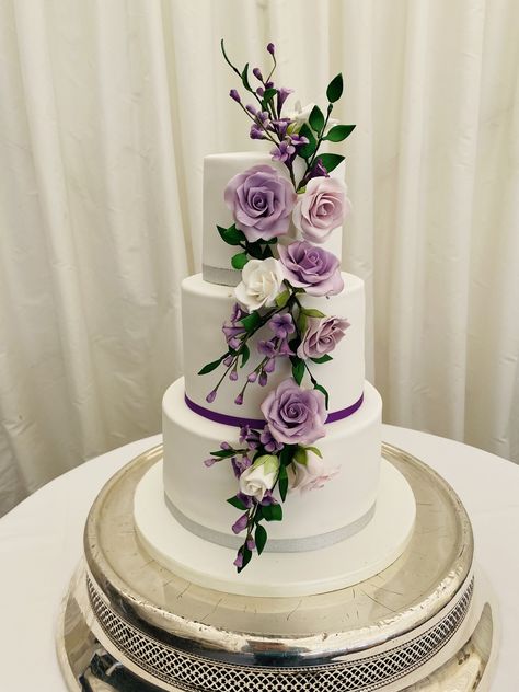 Roxi, 3 tier wedding cake with cascade of wired sugar lilac coloured roses with purple filler flowers Wedding Cake With Lilac Flowers, Lavender And Sage Wedding Cake, Lilac Wedding Cake, Wedding Cake Purple Flowers, Wedding Cakes Lilac, Light Purple Wedding, Coloured Roses, Lavender Wedding Cake, Ur Gay