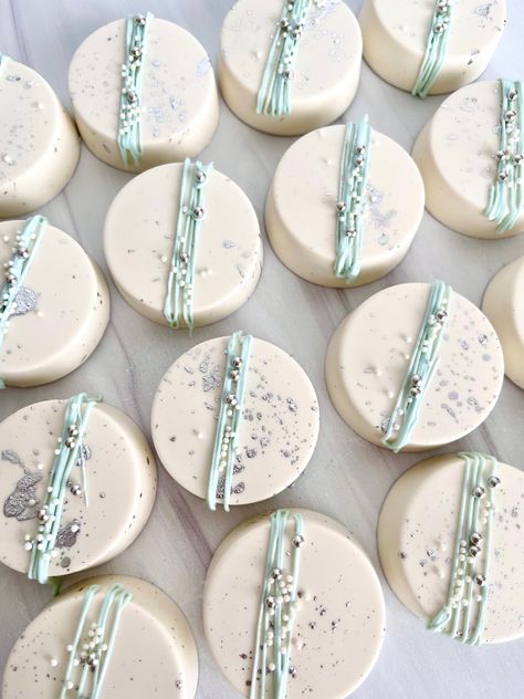 White chocolate dipped Oreos with light blue chocolate lime drizzle and silver sprinkles. Dusty Blue Desserts, Diy Chocolate Covered Oreos, Cinderella Dessert Table, Dusty Blue Wedding Desserts, Dipped Oreos Birthday, Cinderella Desserts, Cinderella Treats, Chocolate Dipped Oreos Wedding, Dusty Blue Cake Pops