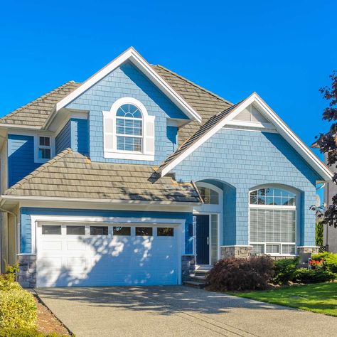 Now's the time to start painting the exterior of your home. Do some research and check out the most popular home exterior paint colors. Sky Blue House Exterior, Popular House Colors Exterior, Tan Siding, Outdoor House Colors, Blue Exterior House Colors, Stucco House Colors, Outside House Paint, Light Blue Houses, Outside House Colors