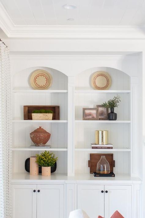 Styled arched built-in shelves are accented with arched millwork and shiplap trim and fitted over white cabinets donning oil rubbed bronze knobs. Shiplap Trim, Built In Around Fireplace, Living Room Built Ins, Built In Cabinet, Bookcase Decor, White Shiplap, Transitional Living, White Marble Countertops, Transitional Living Rooms