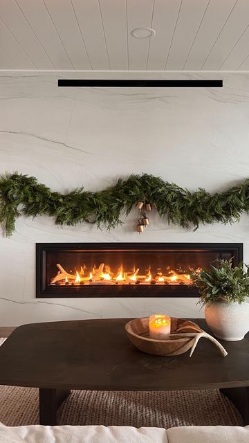 Jennifer Virkus on Instagram: "No Mantle, No Problem! (Comment SHOP for links) Command hooks to the rescue! I used a combination of different hooks and bundle cords to create a “no mantle” fireplace garland moment at the lake house. WHAT I USED: I used 2 (6ft) cedar garlands on each side for a total of 4 garland strands. I stacked them on one another to create a fuller look and secured them with bundle cords and smaller hooks. In true Jenny fashion I just added bells and called it good. For me personally, less is always more 🤍 My garland and bells are from McGee & Co . MHH10 saves you 10% on your order of $100 or more 🤍 HOW TO SHOP- Comment SHOP or tap the link in my Bio to shop my home via the LTK app #fireplacedecor #christmasmantle #modernfireplace" Garland On Electric Fireplace, Garland No Mantle, Garland On Fireplace Without Mantle, Christmas Fireplace Without Mantle, Christmas Fireplace No Mantle, Fireplace With No Mantle Christmas, No Mantle Fireplace Decor Christmas, No Mantle Christmas Decor, No Mantle Fireplace