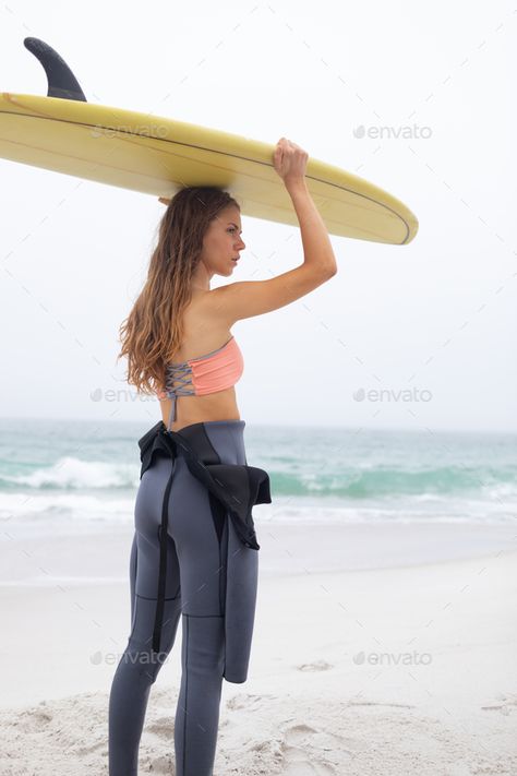 Beautiful young Caucasian female surfer carrying surfboard on her head at beach. by Wavebreakmedia. Rear view of beautiful young Caucasian female surfer carrying surfboard on her head at beach. She is looking away #AD #female, #surfer, #carrying, #Beautiful Female Surfers, Watercolor Illustrations, Pose Reference, Rear View, Surfboard, Carry On, Illustrations, Crop Tops, Quick Saves