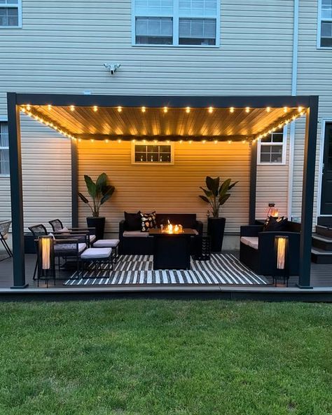 Donice (Dah-neece) on Instagram: "Home lately 🖤  It’s cozy, summer nights on the patio season 🖤  Louvered Pergola @miradoroutdoor  Indoor/outdoor rug @jonathany_official  String lights @jonathany_official   #patio #patioseason #pationights #patiolights #patiodesign #pergoladesign #louveredpergola #louveredroof #louveredpergolas #patiorugs #patiorug #blackpatio #blackpatiodecor #patiostringlights #pergolas #patioinspo #patioinspiration #patioliving #patiolife #modernpatio" Pergola Patio With Lights, Decks With Pergola Ideas, Corner Patio Ideas, Pergola Decorating Ideas, Outdoor Pergola Ideas, Patio Pergola Ideas, Cozy Patio Ideas, Deck Lighting Ideas, Wood Decks