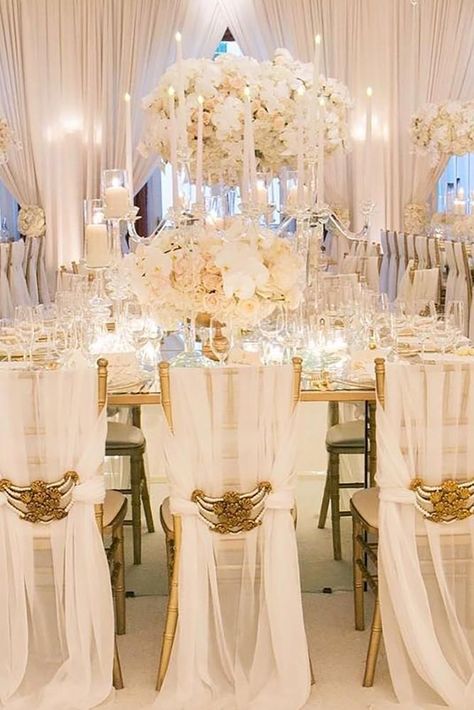 All-white weddings are so romantic and can create an atmosphere of pure elegance or winter fairytale. This subtle and light color can appear on most wedding decorations like centerpieces, flowers, tables. Be creative with an all-white wedding decor to not make it boring. Mix white either with black accents for interesting effect of contrast, or with subtle hues such as pastel pink or beige for natural, chic combinations.#wedding #bride #weddingforward#WeddingDecor #WhiteWedding Champagne White Wedding, White Candles Wedding, Reception Halls, White Wedding Decorations, Wedding Decoration Ideas, Extravagant Wedding, All White Wedding, Sophisticated Bride, White Wedding Flowers