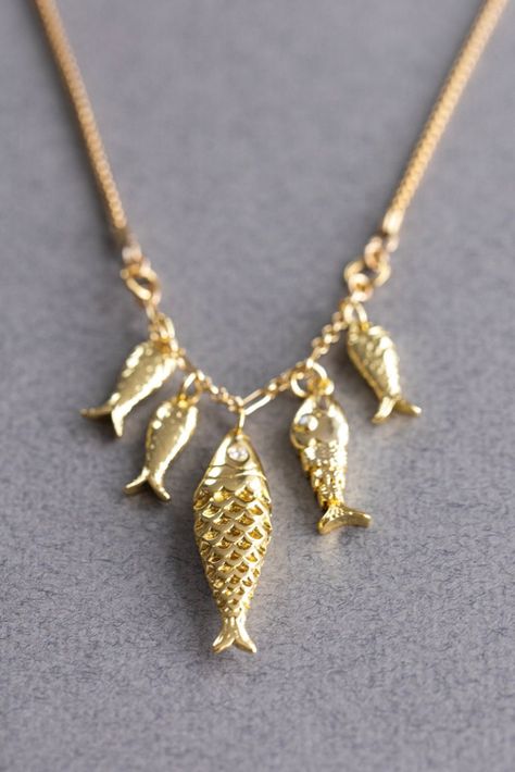 FISH CHARM NECKLACE Five gold fish hang from a foxtail gold chain. DETAILS: * Charms: FIVE Gold plated fish.  * Chain: Gold filled foxtail chain. * Clasp: Lobster. * Extension chain. * Select your size from the drop down menu. PROCESSING TIME: *4-6  business days.  All the jewelry on my site is made by me with love and care. ❤️ GIFT WRAP OPTION: *You can select gift wrap option. Your gift will arrive in a branded Alison Storry Jewelry pouch inside a    branded box. You can also request a message Gold Necklace Charm, Fish Accessories Jewelry, Fishbone Necklace, Fish Necklaces Jewelry, Elegant Yellow Gold Fish Shaped Necklace, Fish Necklace Gold, Fish Charm Necklace, Gold Fish-shaped Necklace For Gift, Gold Fish-shaped Earrings