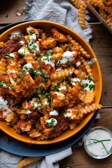 Buffalo Chicken Fries with Creamy Ranch. Crispy crinkle fries loaded in golden fried chicken bites dripping in a buttery buffalo sauce and drenched with a homemade creamy and herbaceous ranch sauce finished with some freshly chopped chives. Fried Chicken Bites, Buffalo Chicken Fries, Buffalo Fries, Crinkle Fries, Buffalo Chicken Nachos, Chicken Fries, Ranch Sauce, Baked Rigatoni, Chicken Rice Recipes