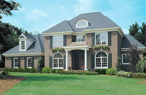 This home's commanding brick exterior with arch-topped windows, keystone arches, quoins, covered entry and hip roof creates a stunning presence, while its spacious interior is equally impressive. Brick House Plans, Covered Entry, Second Floor Balcony, Colonial Style House Plans, American House Plans, Colonial House Plans, Colonial Design, Custom Home Plans, Brick Exterior