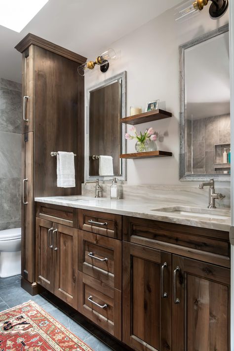 Transform your bathroom into a functional and stylish space with Bridgewood cabinetry. This newly remodeled bathroom was designed by Kim Feld at Perspective Cabinetry & Design with Bridgewood stained cabinets.  Contact us at 314-716-3525 or visit our website at www.perspectivecabinetry.com #bathroomremodel #customdesign #StLouisbusiness #bridgewoodcabinetry Bathroom With Walnut Cabinets, Bathrooms With Brown Cabinets, Knotty Alder Bathroom Cabinets, Alder Bathroom Cabinets, Dark Stained Cabinets, Stained Cabinets, Staining Cabinets, Brown Cabinets, Walnut Cabinets