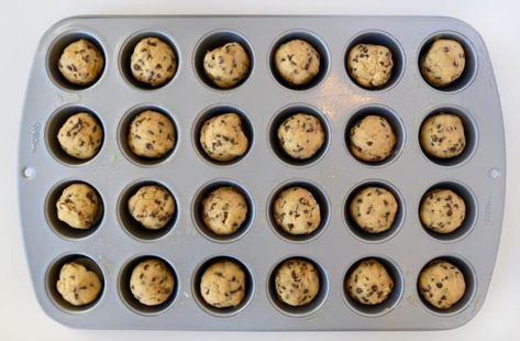 A mini muffin tin containing balls of unbaked chocolate chip cookie dough Cookies In Mini Muffin Tins, Cookies In Muffin Tin, Chocolate Chip Cookie Muffins, Pillsbury Chocolate Chip Cookies, Mini Muffin Tin Recipes, Mini Chocolate Chip Muffins, Chocolate Chip Cookie Cups, Cookie Cups Recipe, Mini Chocolate Chip Cookies