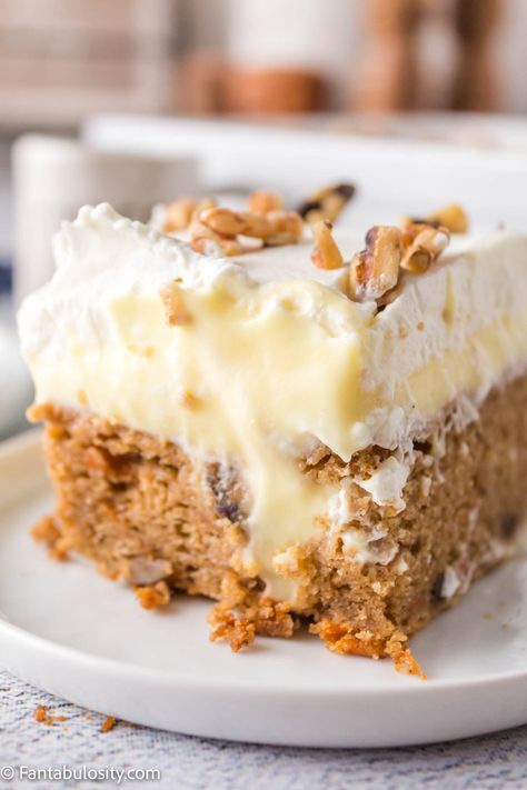 Slice of carrot cake poke cake on a white plate. Poke Carrot Cake Recipe, Carrot Cake From White Box Cake, Boxed Carrot Cake Mix Ideas, Carrot Cake Recipe From Box Cake, Carrot Cake Box Mix Recipes, Carrot Poke Cake Recipe, Cake Mix Carrot Cake, Carrot Poke Cake, Carrot Cake Poke Cake