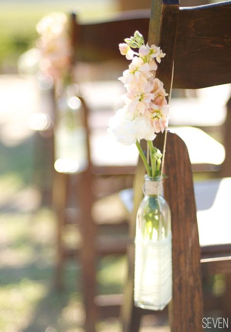 Close up of how to hang....    {ceremony} Use flowers and recycled bottles as aisle markers. Tie to chairs or sit them on the ground close by. Can use a cheaper flower or fillers such as babys breath - use mason jars Bohemian Wedding Aisle, Wedding Aisles, Aisle Markers, Aisle Flowers, Cheap Flowers, Aisle Decor, Wedding Aisle, Wedding Chairs, Chair Decorations