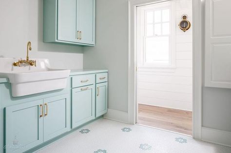 Tiffany blue laundry room is clad in white and Tiffany blue mosaic floor tiles accenting Tiffany blue cabinets donning brass pulls and a Tiffany blue countertop holding an apron sink finished with a brass vintage faucet between Tiffany blue upper cabinets mounted to a light gray wall. Gretchen Black, Bathroom Vanity Blue, Blue Laundry Rooms, Small Craft Rooms, Fishing Room, Blue Shower Curtains, House Of Turquoise, Light Grey Walls, Laundry Room Cabinets