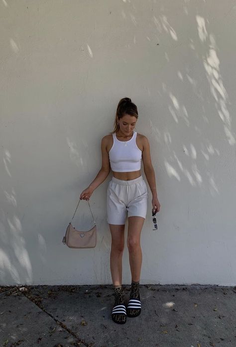 white halter tank top paired with grey or gray sweatshorts long socks and sandals or slide and a purse and sunglasses #accessories #purse #glasses #ponytail #lazy #chill laidback outfit. ponytail hairstyles.  Pink prada purse Gray Sweatshorts Outfit, Sweatshorts Outfits, Grey Shorts Outfit, White Shorts Outfit, Slides Outfit, Shorts Outfits Women, Model Outfit, Thrifted Outfits, 90s Fashion Outfits